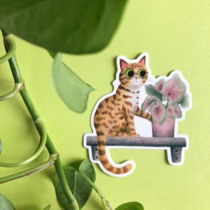 Pegatina de una ilustración de Mar Villar de un gato a punto de tirar una planta